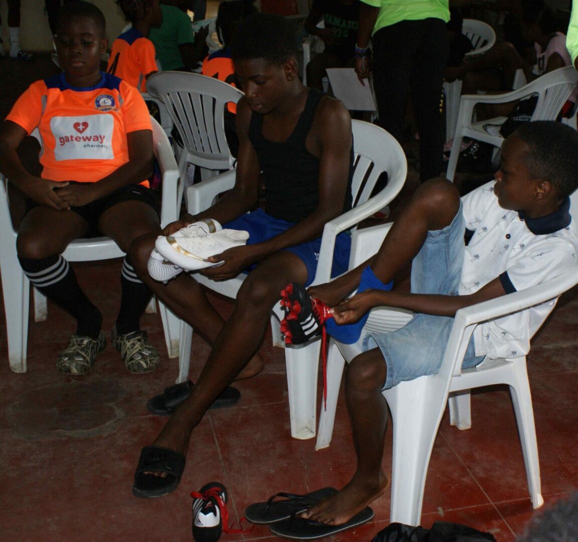 A group of people sitting in chairs on the ground.