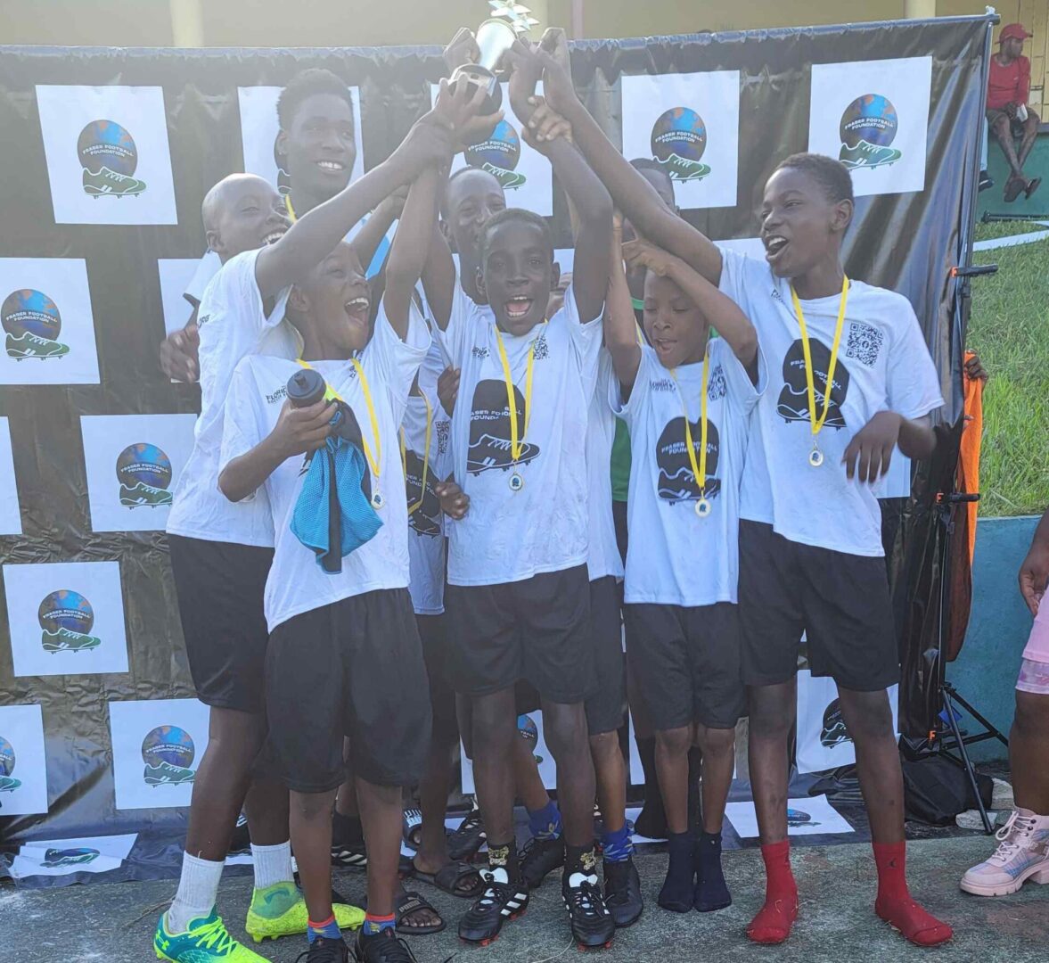 A group of young men holding up their trophy.