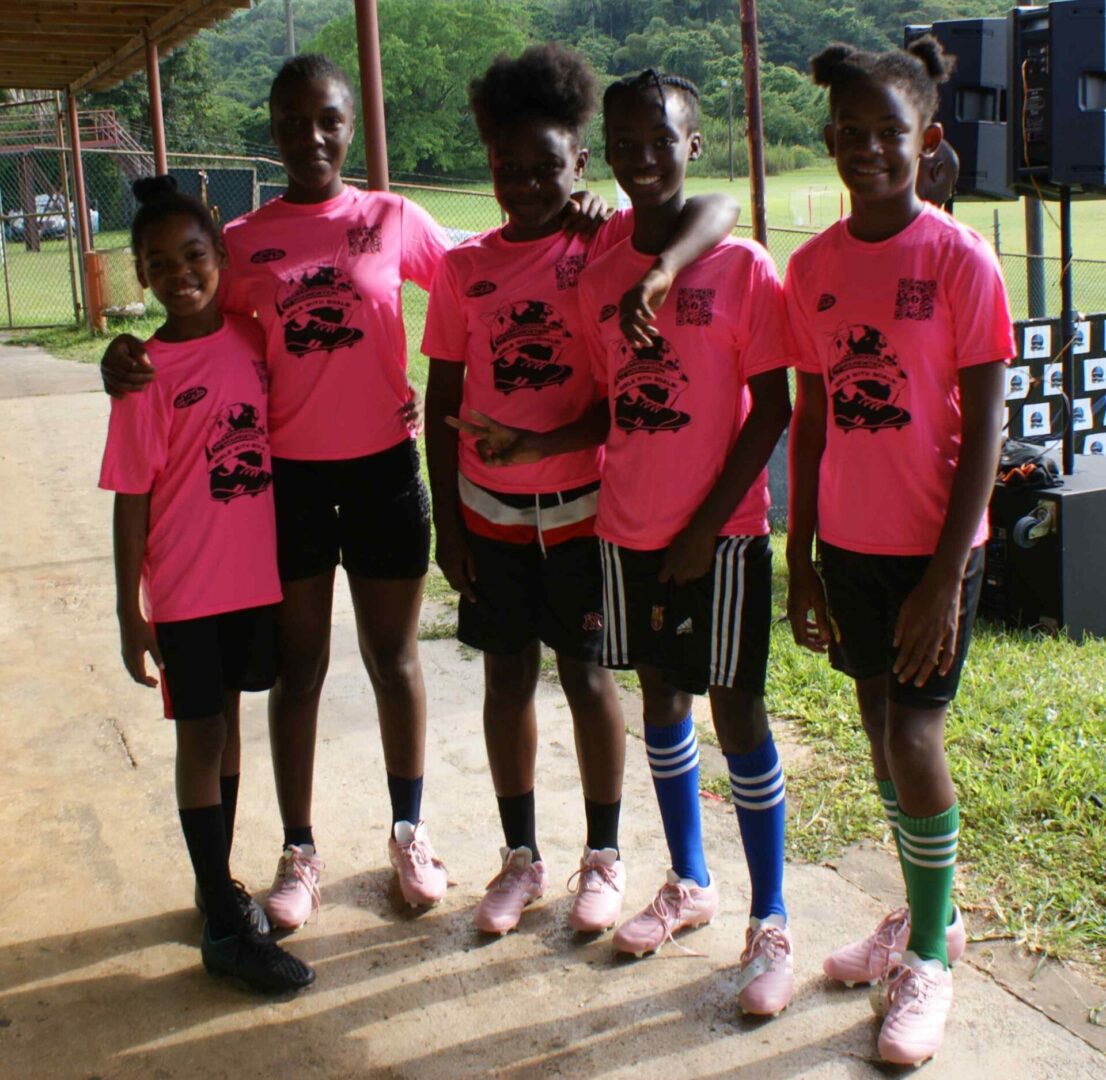 A group of girls in pink shirts and black shorts.