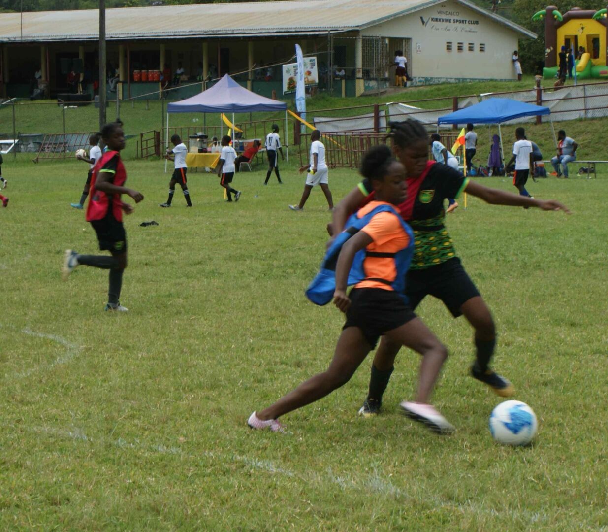 A group of kids playing soccer on the field