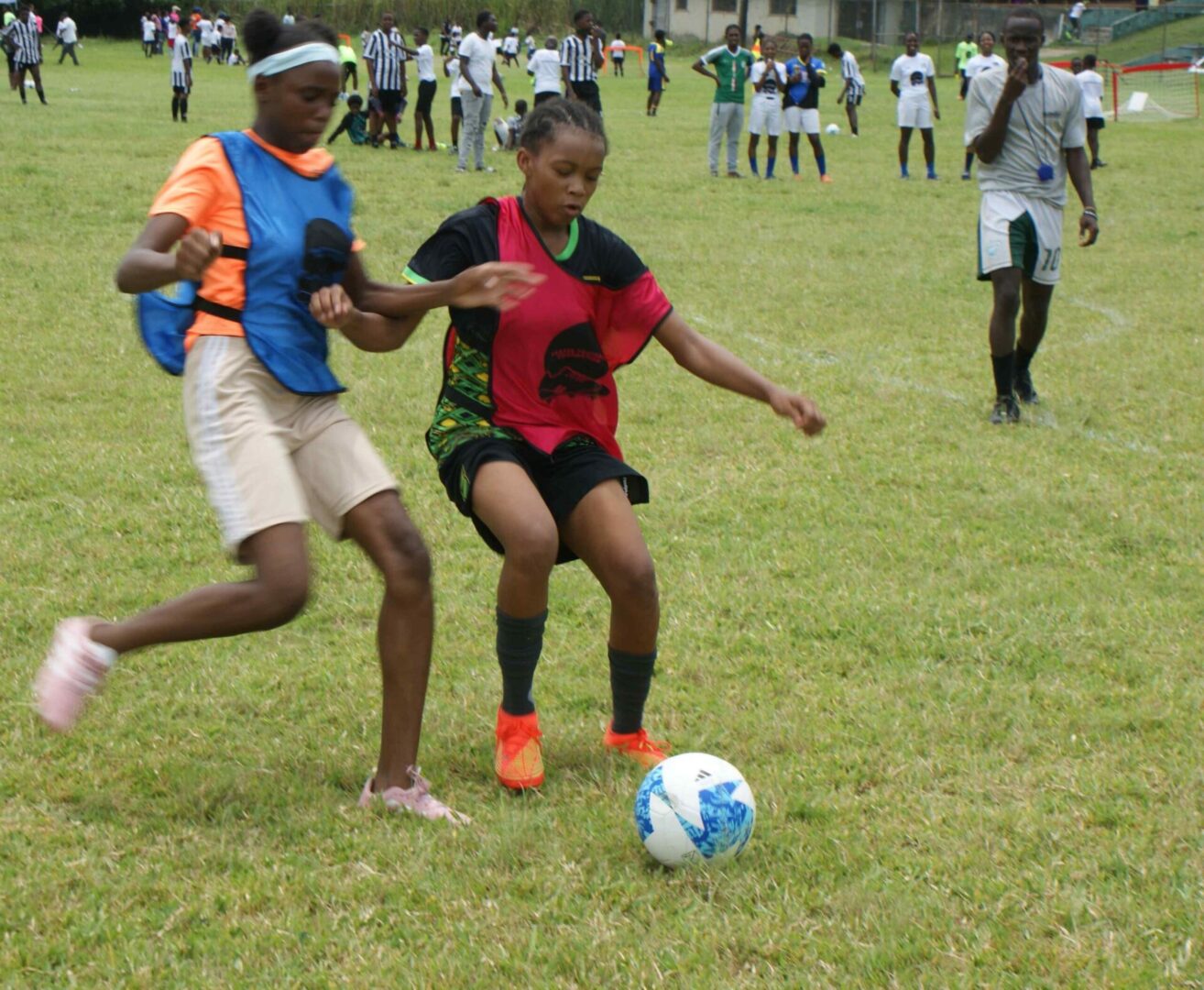 Two young boys playing soccer on a field.