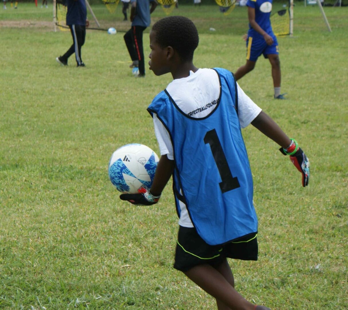 A young boy is playing soccer on the field.